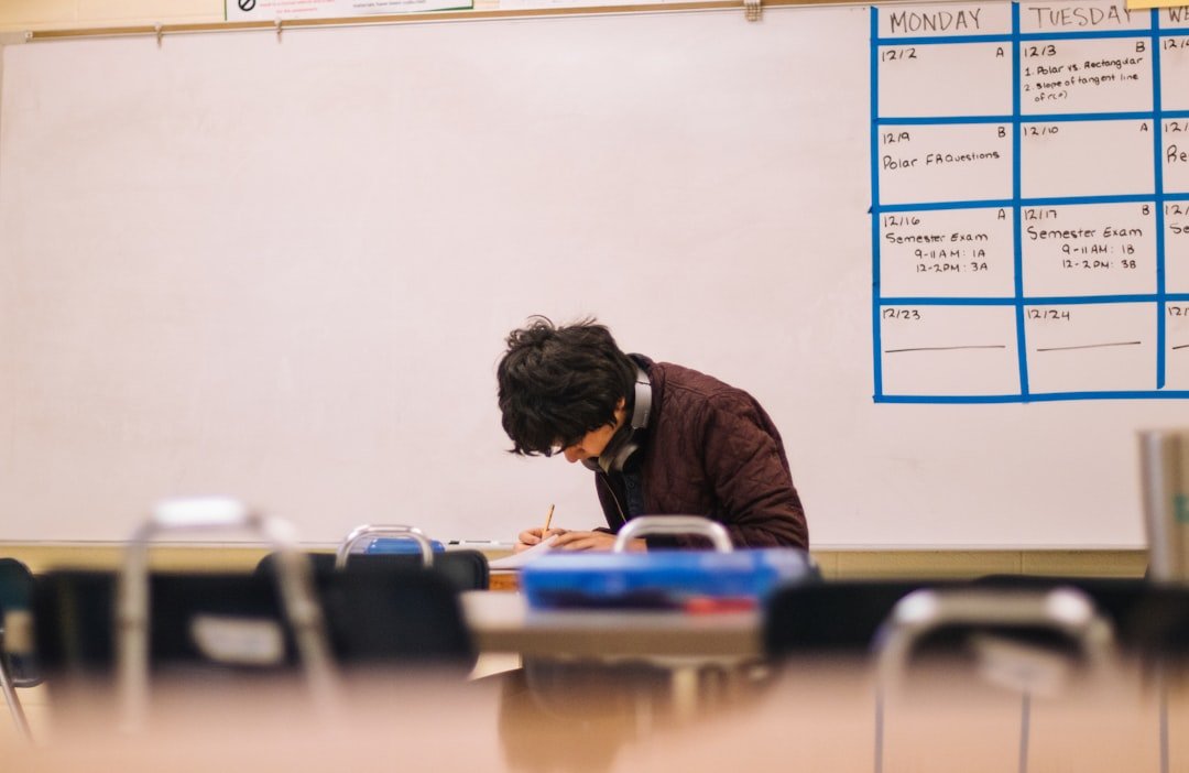 Student writing by hand on paper during a classroom lesson