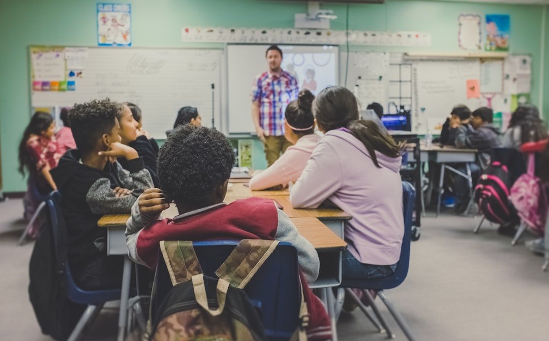 Students in a classroom with a teacher using digital technology