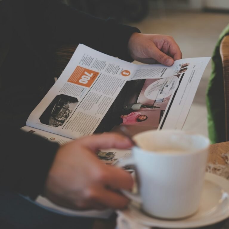 Glasses and coffee on a newspaper representing critical media literacy and source evaluation