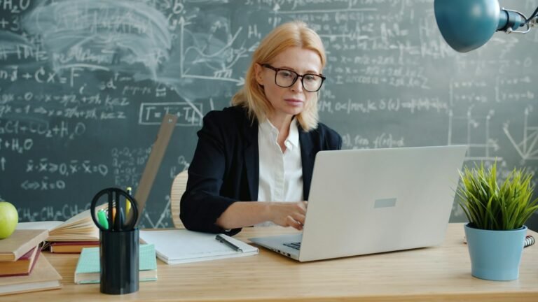 Teacher using a laptop for school-wide student behavior and PBIS data review